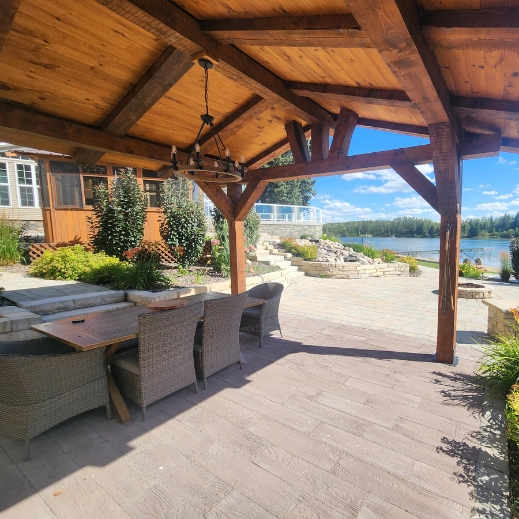 Custom built gazebo with a chandelier and patio table and chairs overlooking the lake