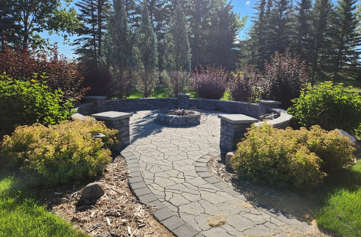 Firepit, patio and pillar wall with surrounding landscaping